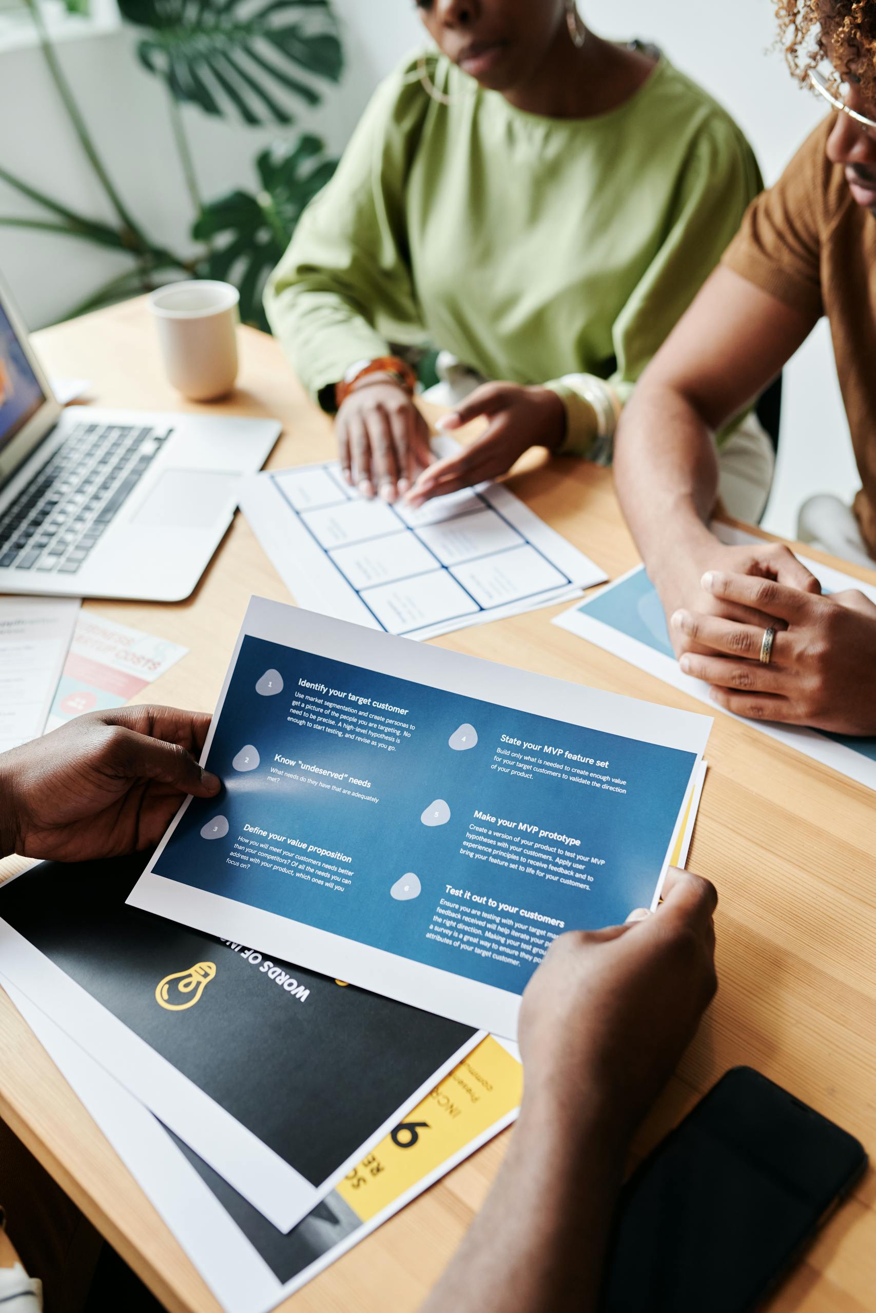 team members collaborate over documents in an office setting discussing plans and data. 7971192 scaled