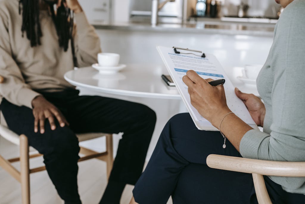 Employee Benefits Administration Services — Enrollment & Compliance 1 Two people in a benefits consultation, one filling out an enrollment form on a clipboard