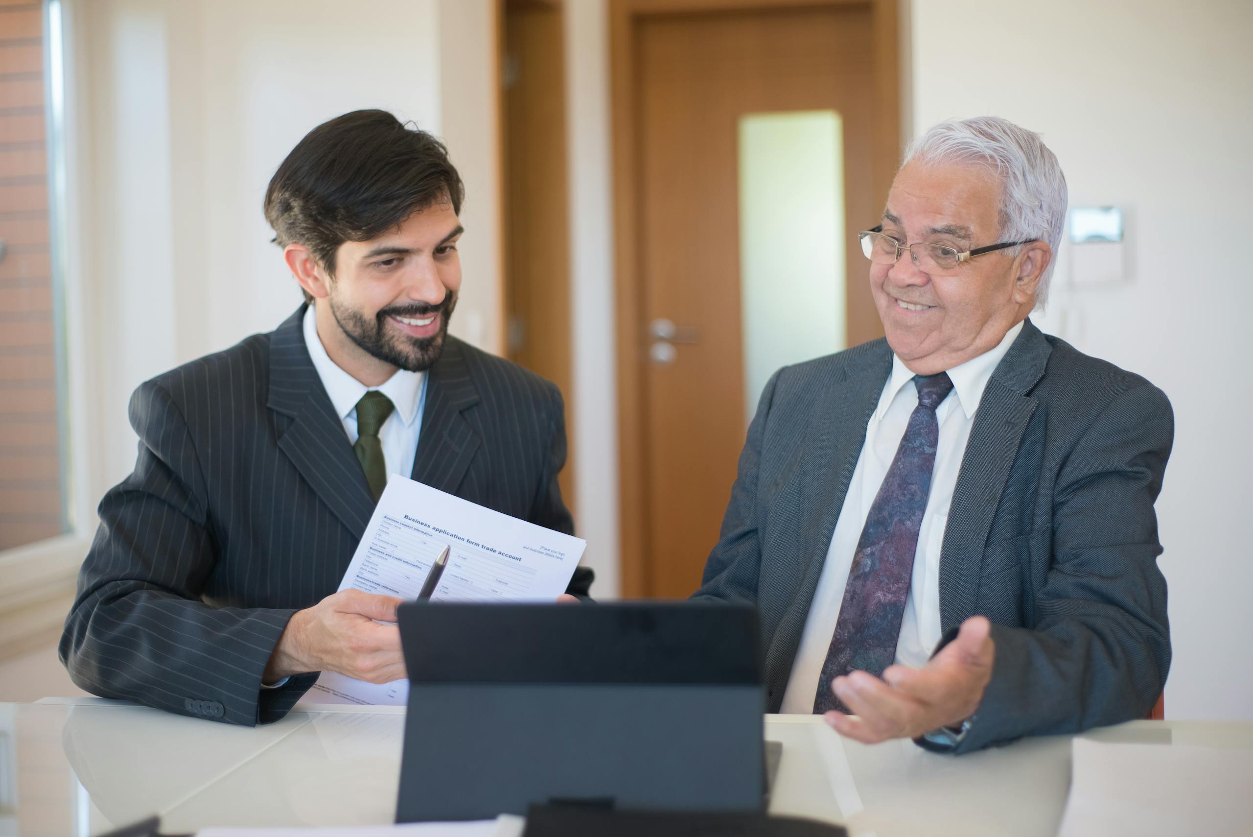 Two businessmen discussing a real estate deal in a modern office setting.