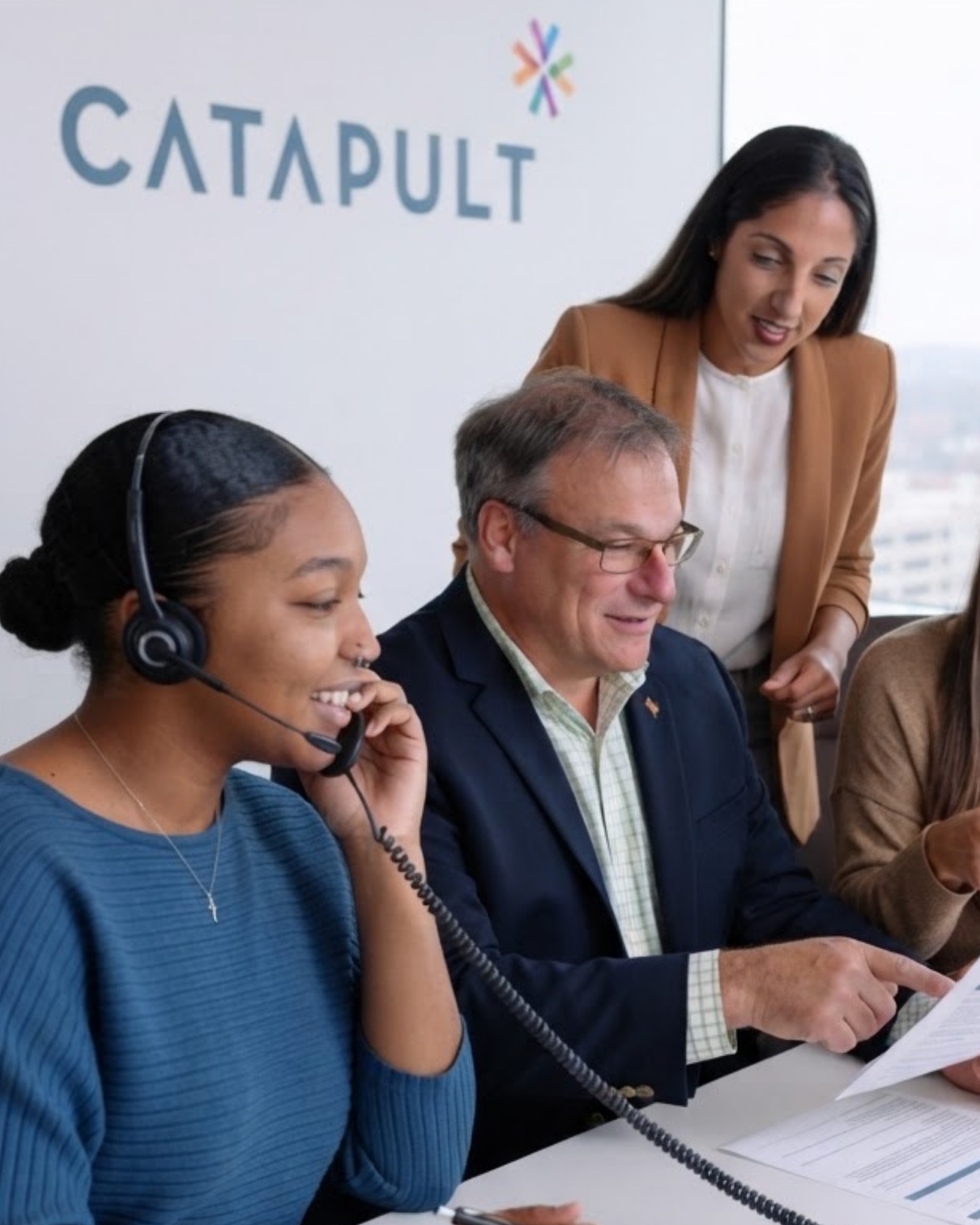 Catapult background screening team members on a phone call reviewing a screening report together
