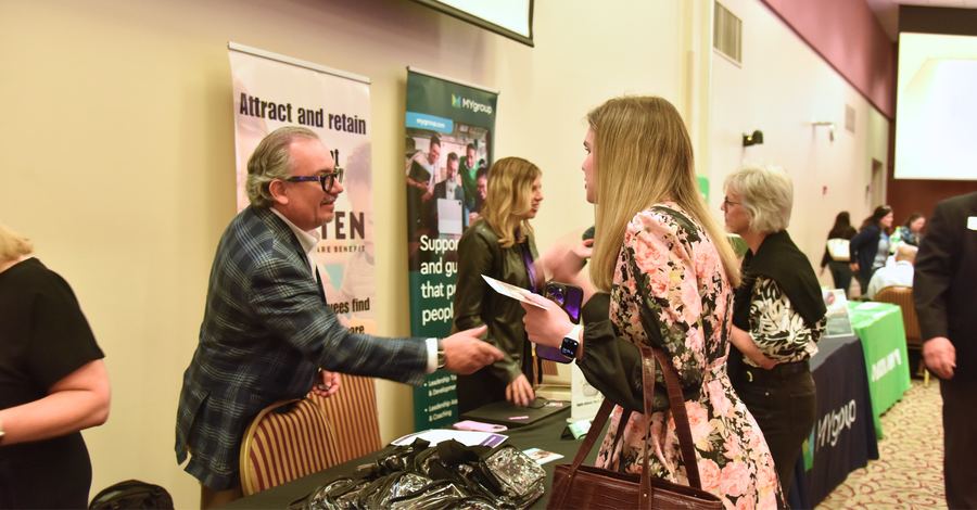 2027 Leadership & HR Conference | Concord, NC 8 Attendee talking with a sponsor at their booth