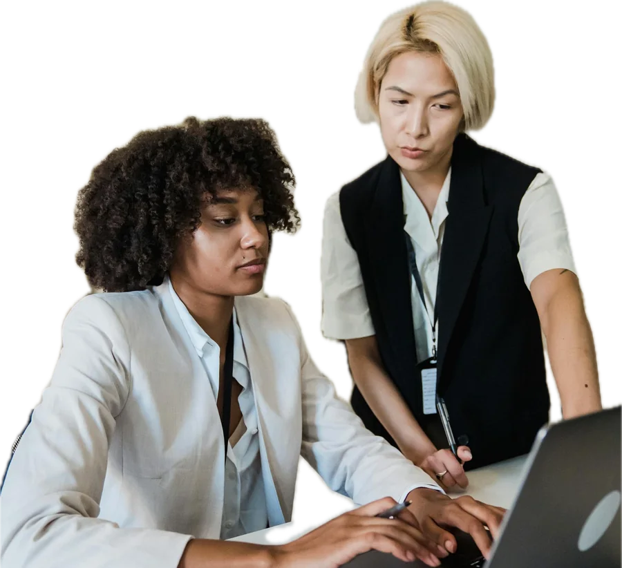 A supervisor coaching a new employee at a laptop